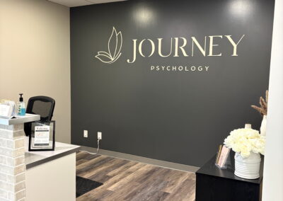 Journey Psychology reception area with logo wall, front desk, and modern welcoming interior.