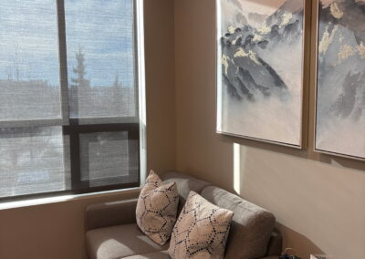 Welcoming counselling office at Journey Psychology featuring a comfortable loveseat, decorative pillows, and calming wall art.