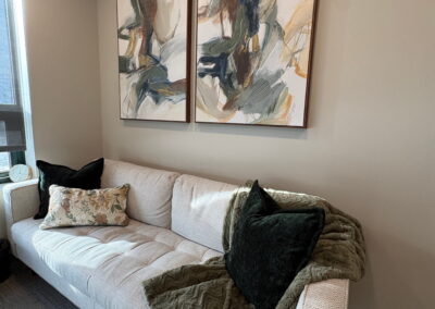 Cozy counselling space at Journey Psychology featuring a neutral-toned couch, soft blanket, and abstract wall art.