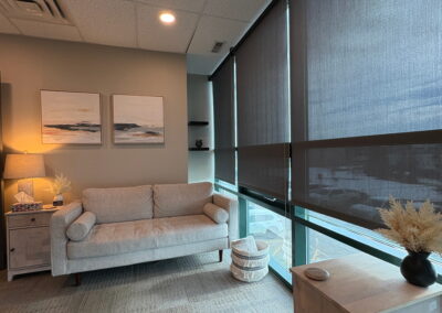Comfortable therapy room at Journey Psychology featuring a neutral-toned couch, soft lighting, and large windows.
