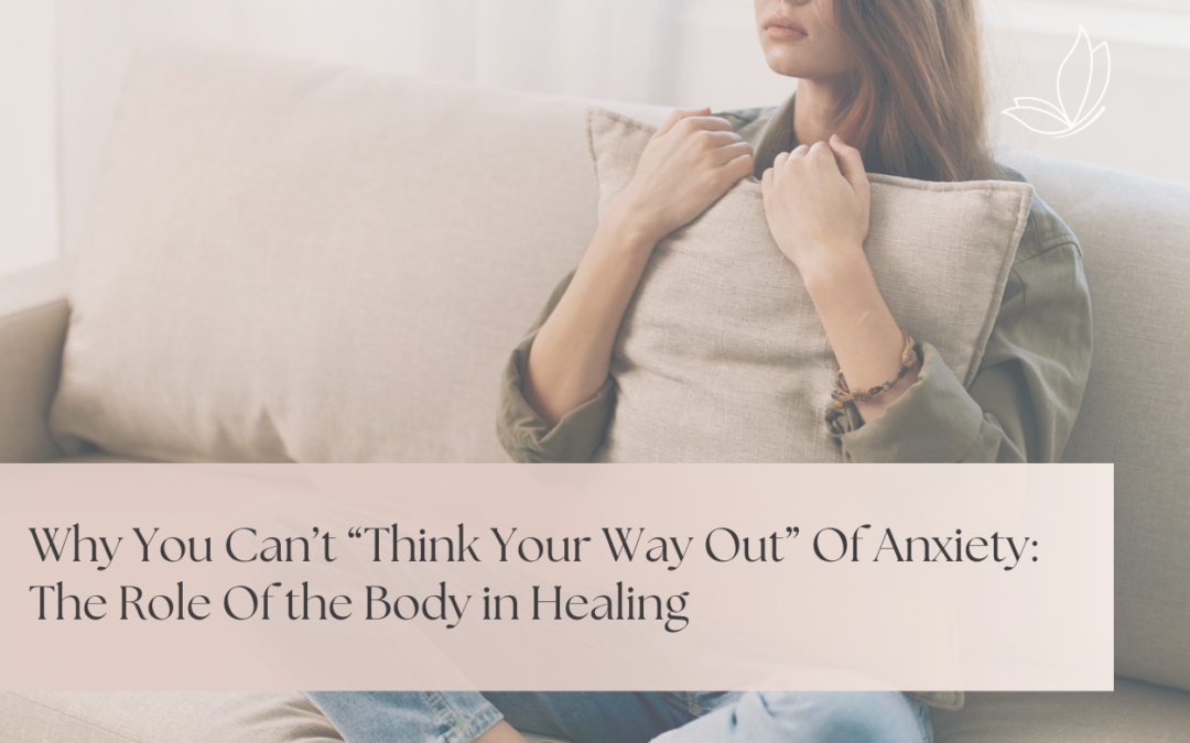 Woman sitting on a couch holding a pillow, representing somatic therapy for anxiety in Sherwood Park and body-based healing approaches.
