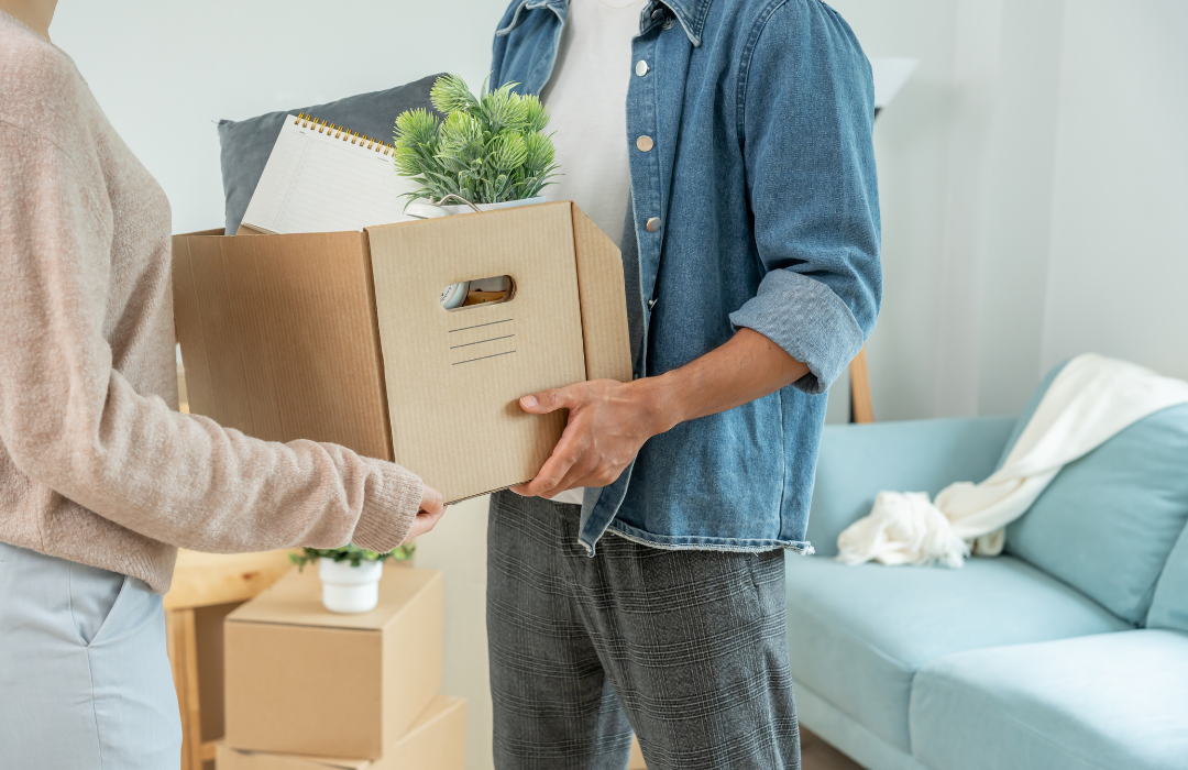 A person assisting another with a moving box during a major life change, highlighting life transition therapy in Sherwood Park.